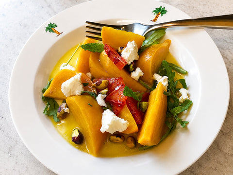 Photograph of a plate of KATZ roasted golden beet, pistachio & goat cheese salad